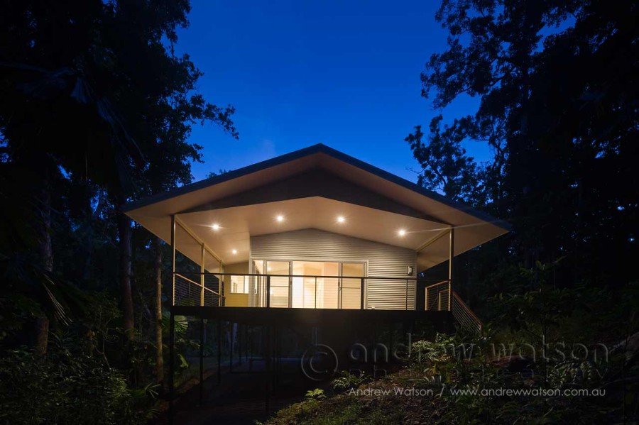 Rainforest home illuminated at twilight