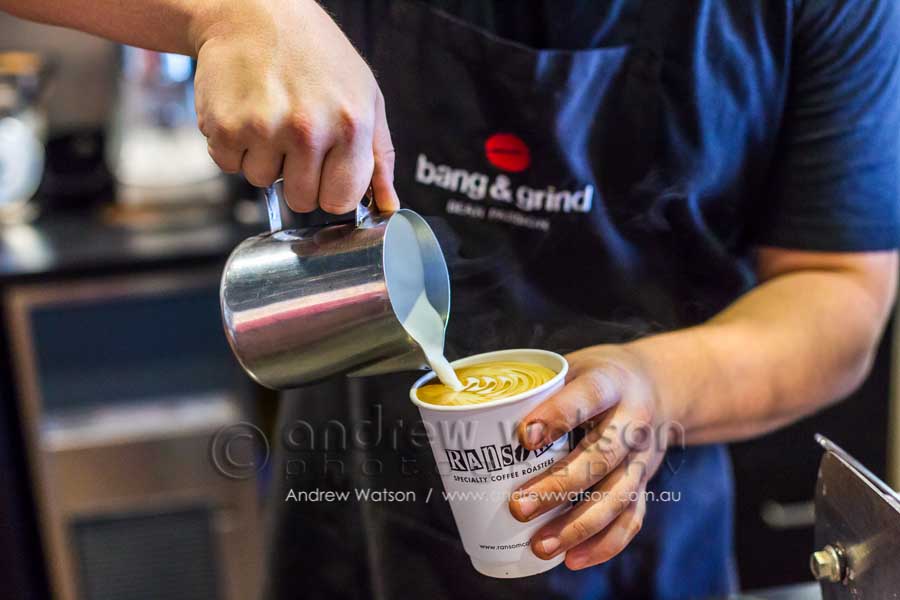 Barista pouring the milk in a coffee at Bang & Grind Cafe, Cairns