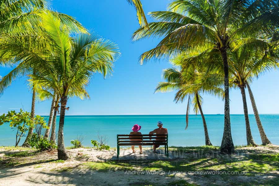 Couple relaxing amidst the coconut palms of Clifton Beach, Cairns