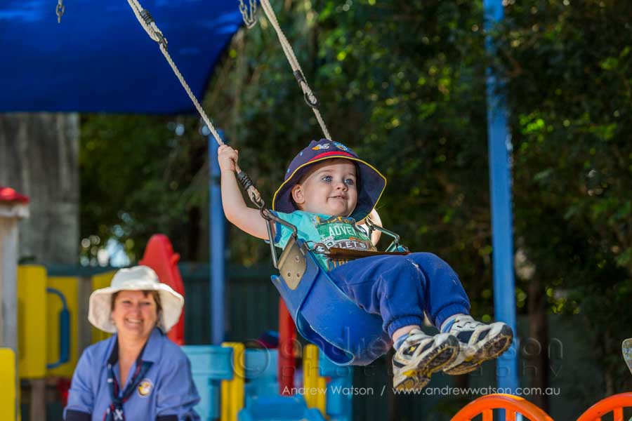 Child playing on swing in the playground at Pelicans Childcare
