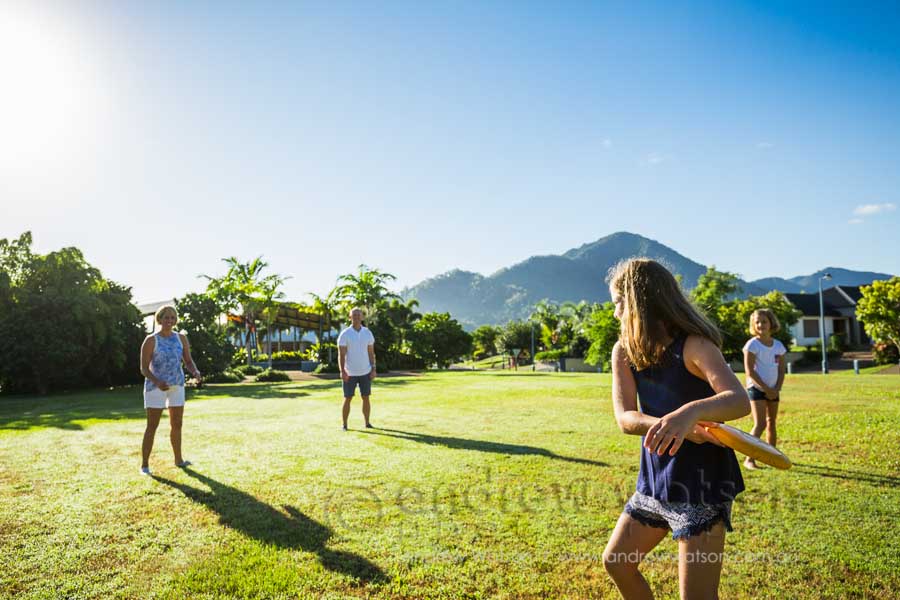 Lifestyle image of young family playing frisbee in park