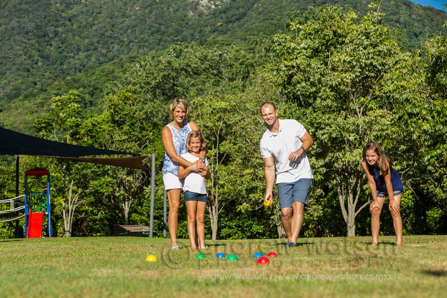 Lifestyle image of young family playing bocce in park