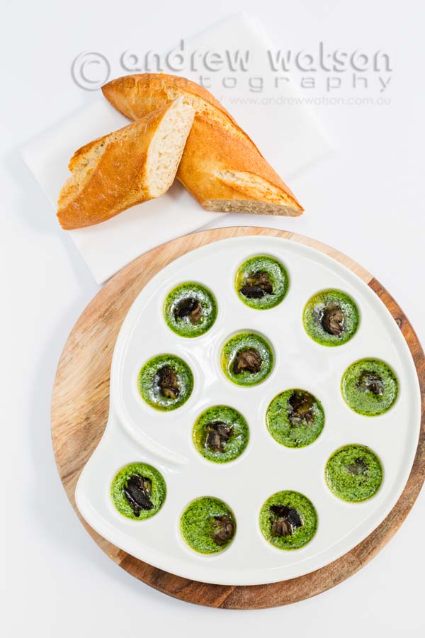 Image of snails cooked in garlic parsley butter with a baguette