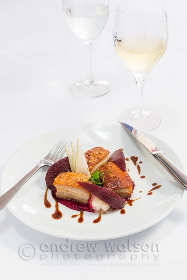 Image of French-style pork belly dish with red wine poached pear