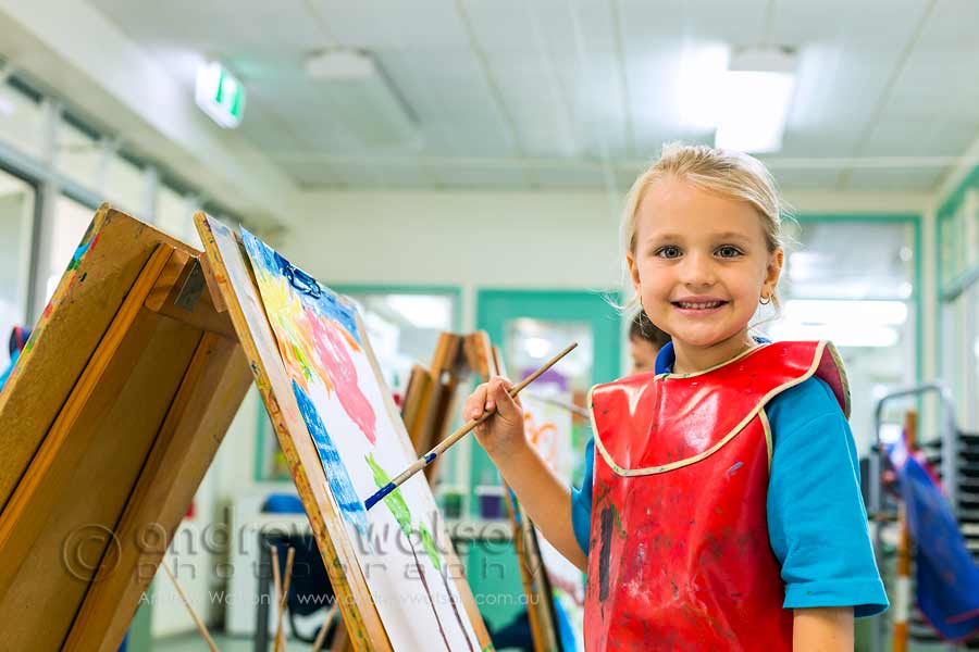 Image of young student with paint and easel