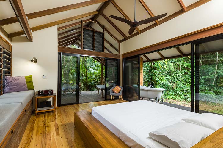 Bedroom interior with outdoor deck and bathtub at a Daintree holiday home