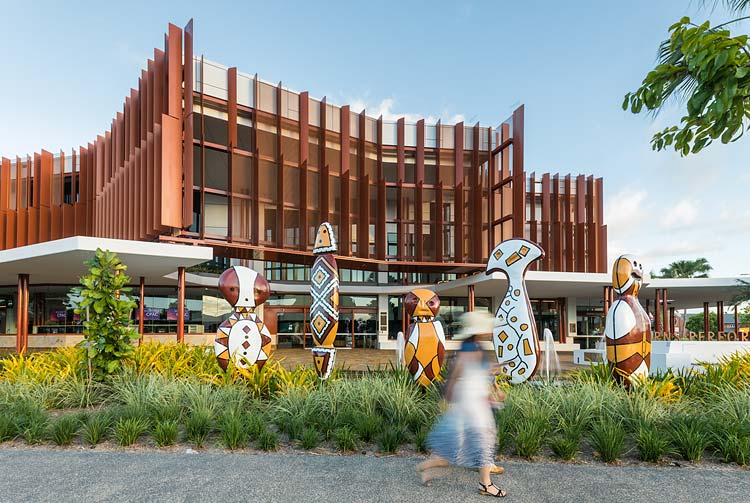 Blurred movement of people walking past indigenous sculptures at Cairns Performing Arts Centre