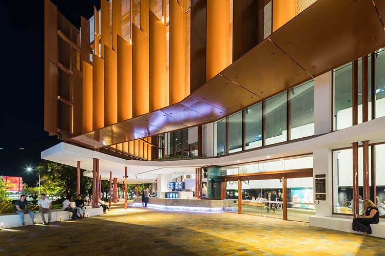 People sitting outside of the Cairns Performing Arts Centre at night