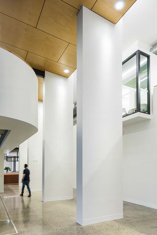 A man walking through high-ceiling gallery space
