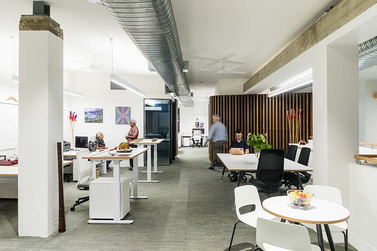 Workers in a busy office space at Bulmba-ja Arts, Cairns