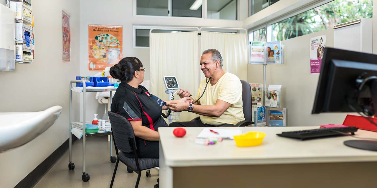 A healthcare student taking the blood pressure of his teacher