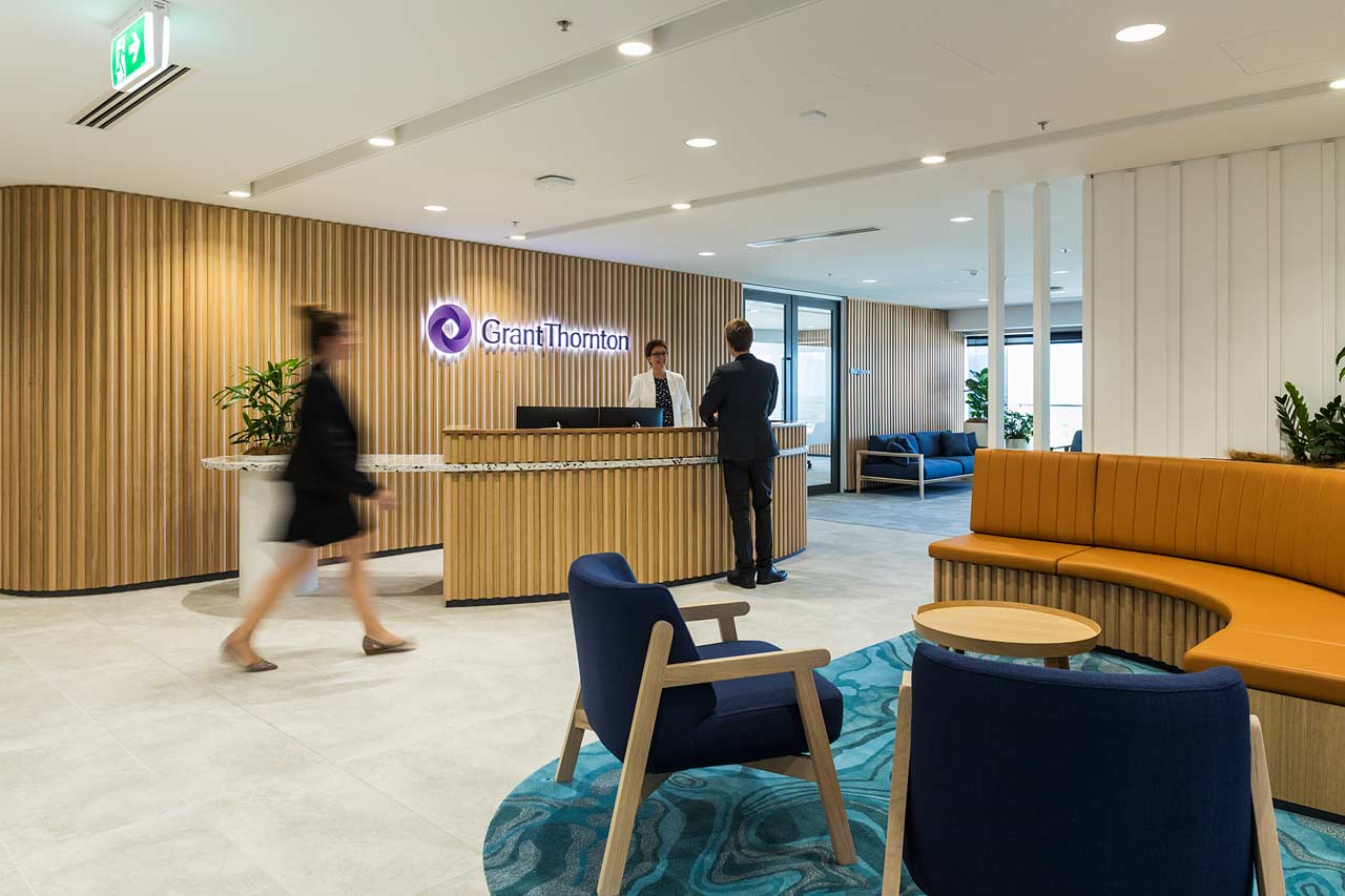 Staff greeting client at reception and lounge area in corporate office