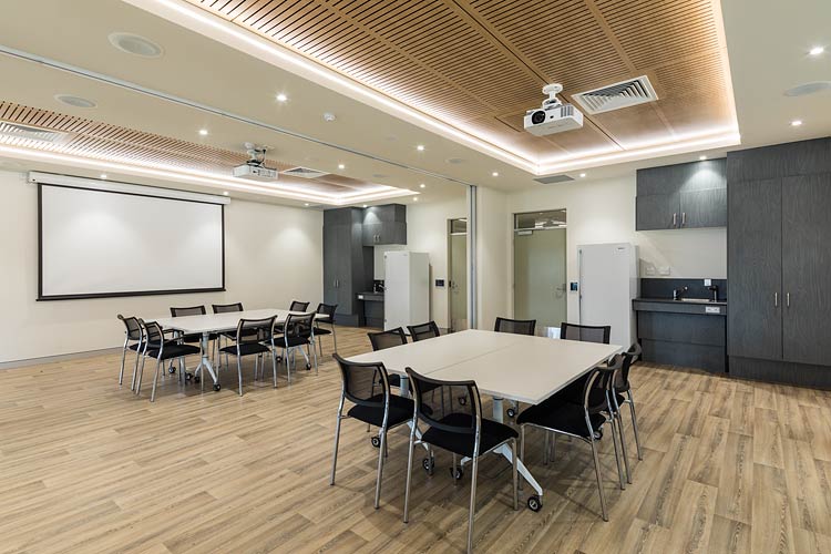 Meeting room featuring tables and projector screen