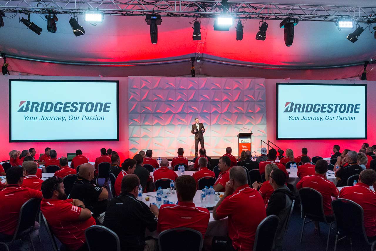 Ppeaker giving presentation on stage at Bridgestone Conference