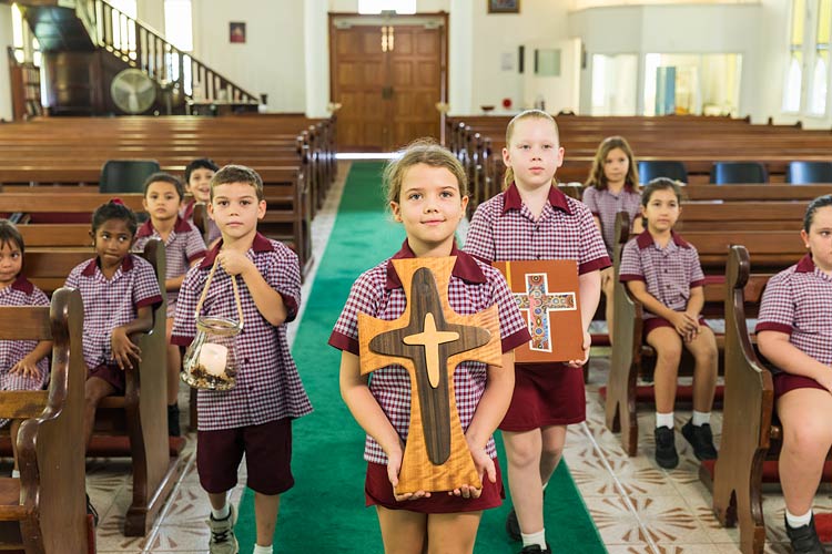Young students conducting a religious mass in a Catholic school church