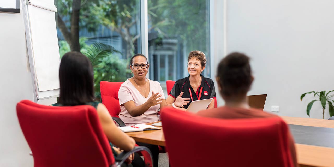 Indigenous business student presenting at a meeting with teacher looking on