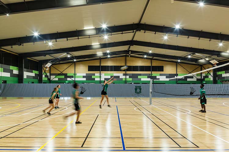 Interior of Trinity Bay High School multi purpose hall with kids playing game of volleyball