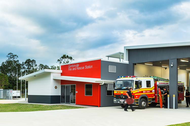 Exterior of the Gordonvale Fire Station building with staff readying fire truck equipment
