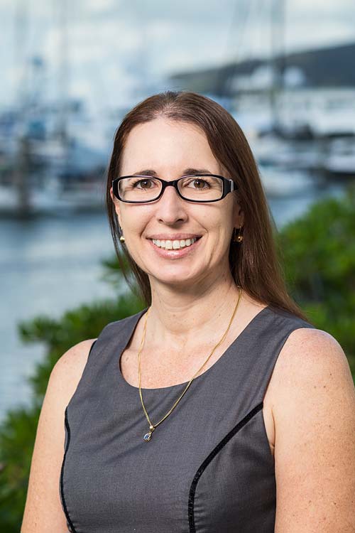 Corporate headshot of a female accountant with harbour background