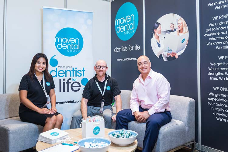 Dental suppliers sitting in booth at conference tradeshow