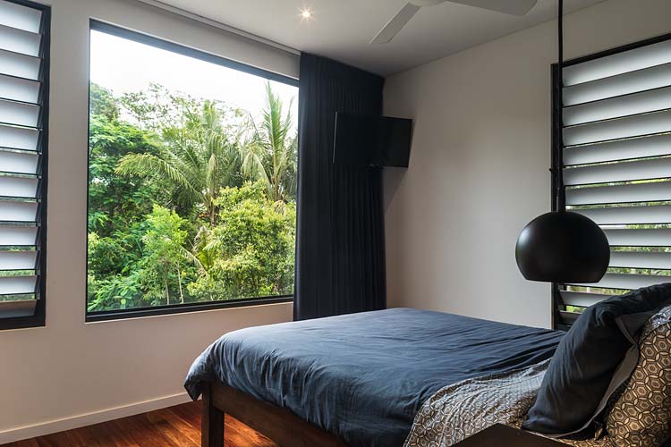 Bedroom interior with views out to rainforest surroundings