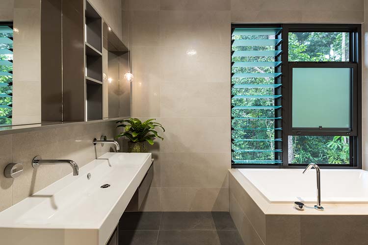 Bathroom interior with basin, bath and views of surrounding rainforest