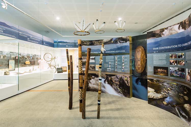 Interior of the Cairns Museum showing a visitor viewing the ‘Cairns Over Time’ exhibition
