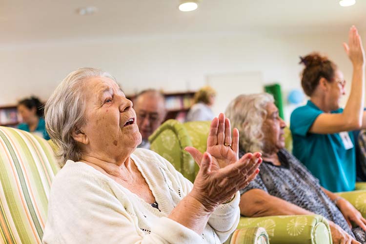Female residents of an aged care home enjoying a sing-a-long