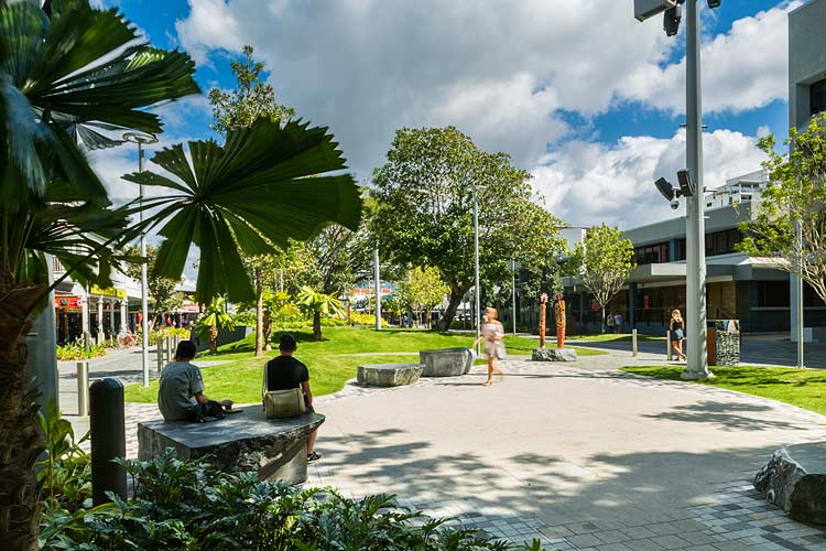 People sitting amidst the urban park elements of the Shields Street Heart Project in Cairns