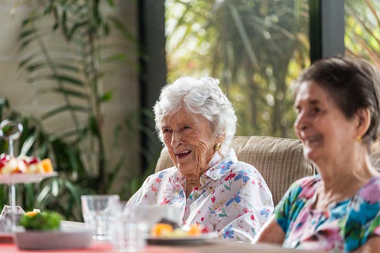 Aged care home resident talking over morning tea
