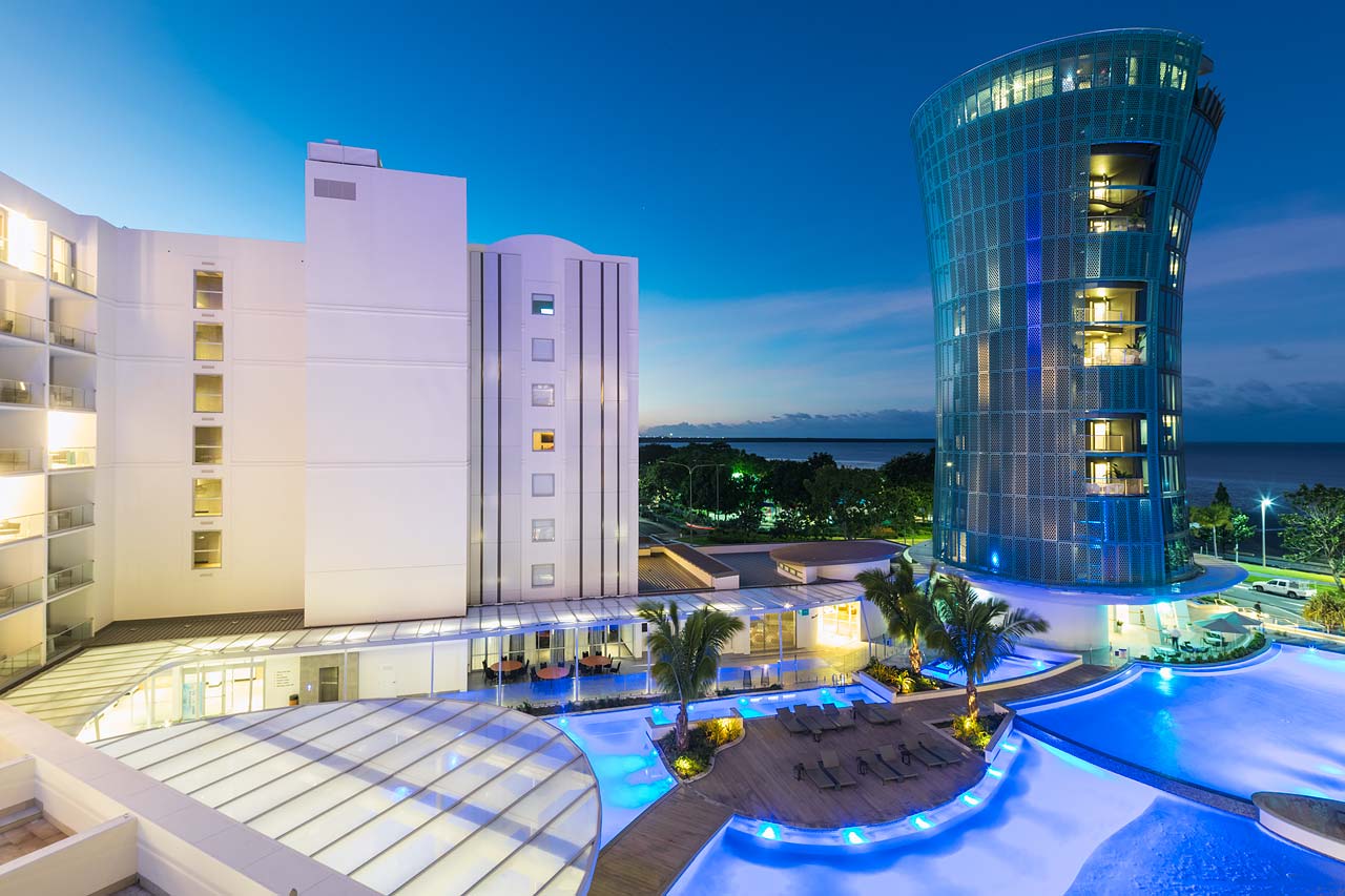 View across the lagoon style resort pool to the tower at Hotel Riley in Cairns