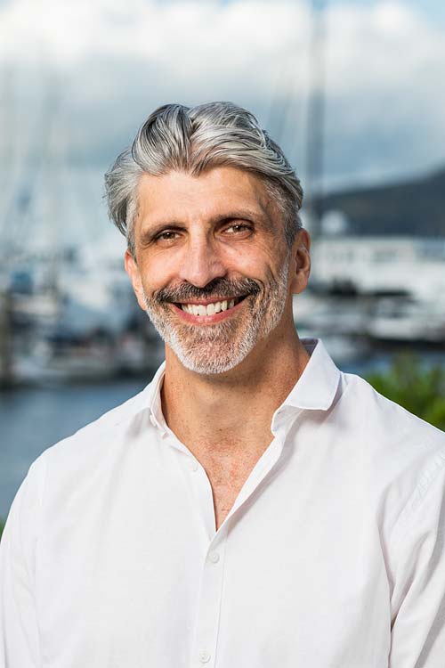 Corporate headshot of a male accountant with harbour background