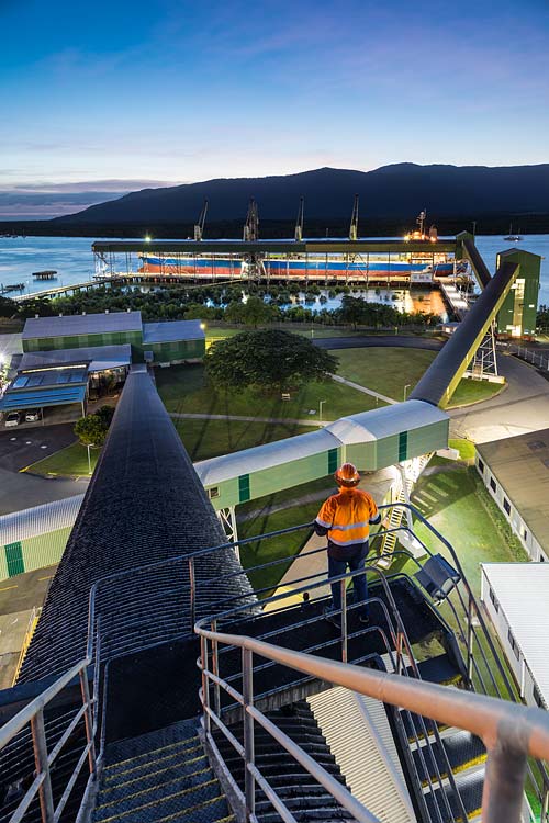 Twilight at the Cairns Bulk Sugar Terminal with worker looking out over cargo ship ready for loading