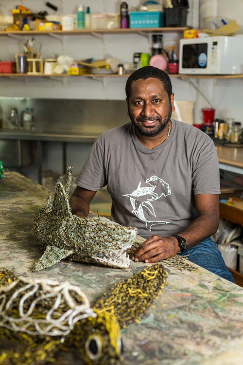 Portrait of Torres Strait Islander artist Jimmy Kenny Thaiday with artworks made from abandoned fishing nets