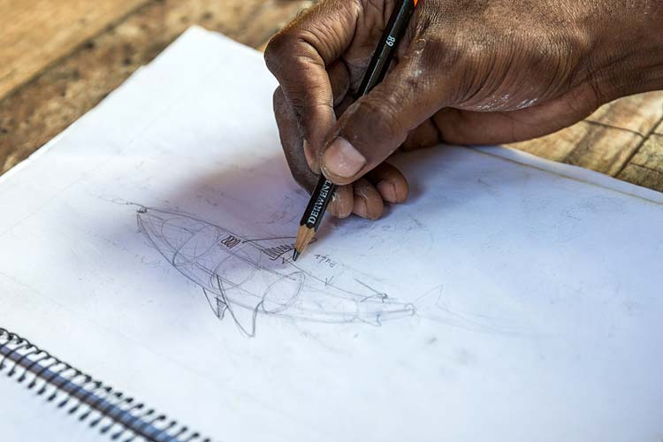 Hand of Torres Strait Islander artist sketching a drawing of a shark