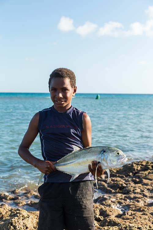 A Torres Strait Island boy holding a freshly caught fish