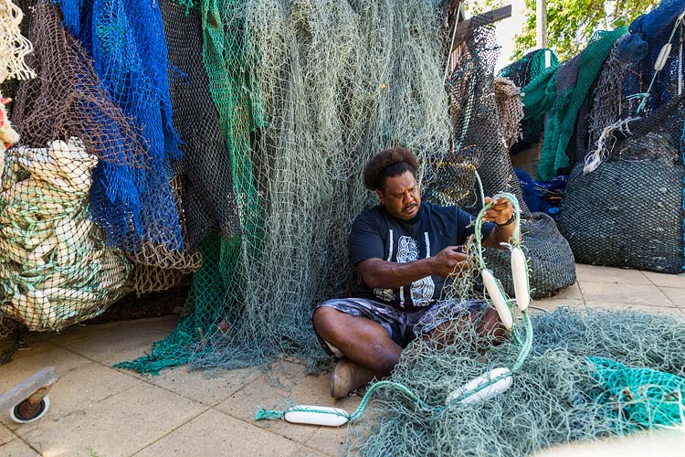Portrait of an Erub Island man cutting apart abandoned fishing nets for artwork materials