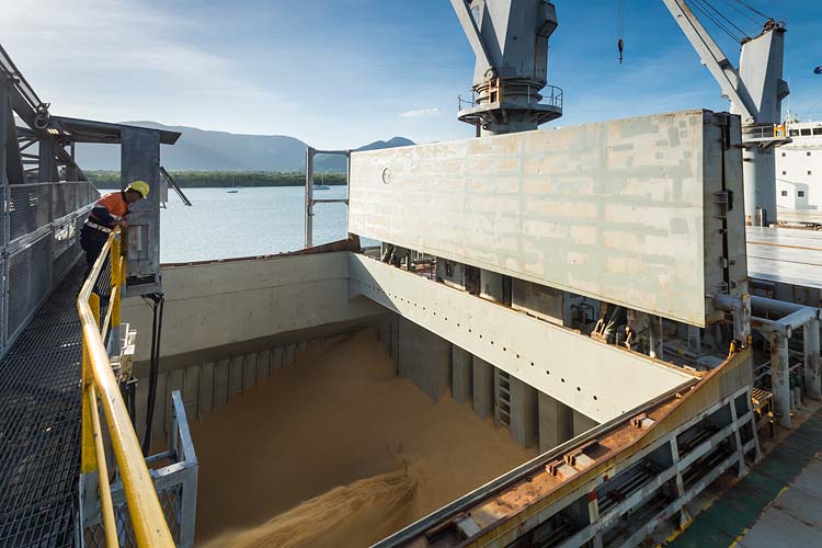 A worker monitors sugar being loaded into ship's hold at the Cairns Sugar Terminal