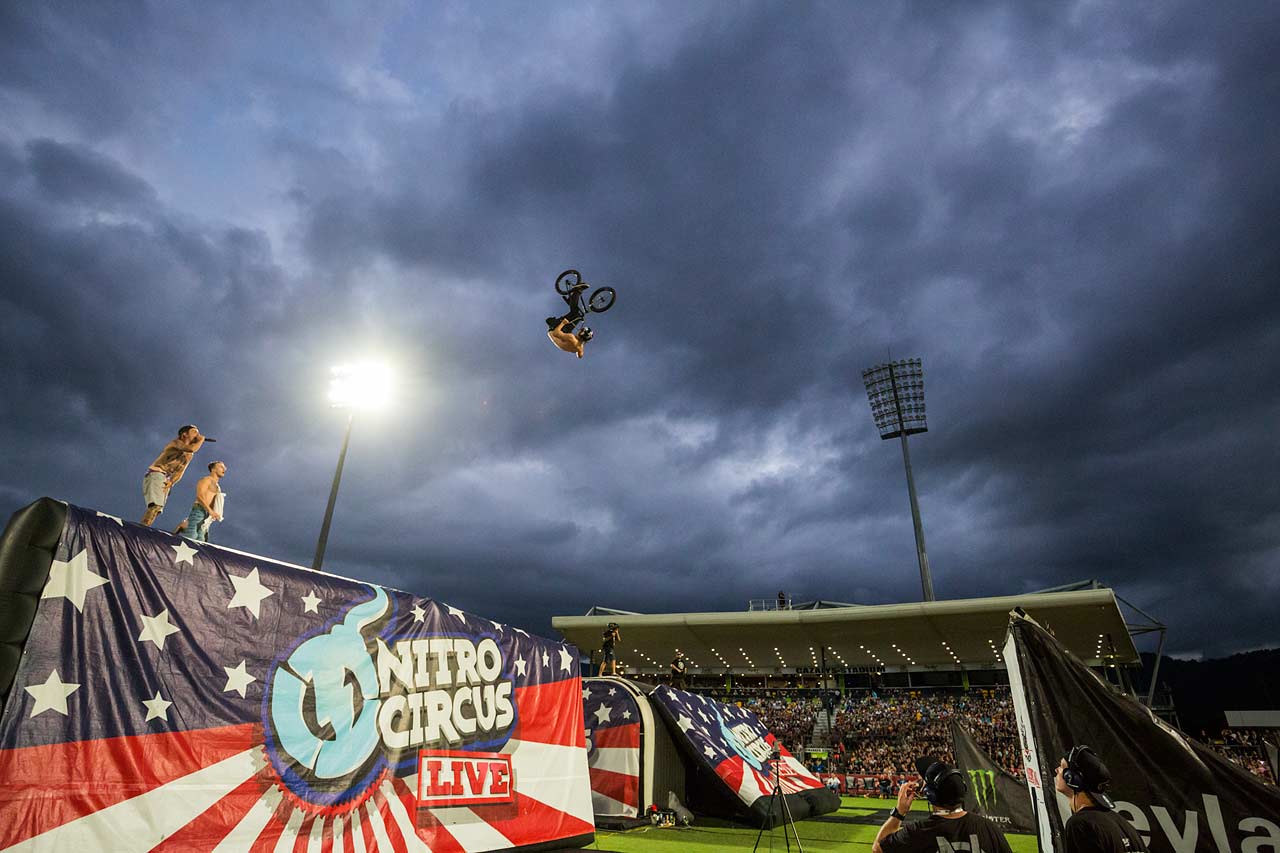 Ryan Williams of Nitro Circus upside on a bmx bike - doing an aerial trick at the Nitro Circus performance in Cairns