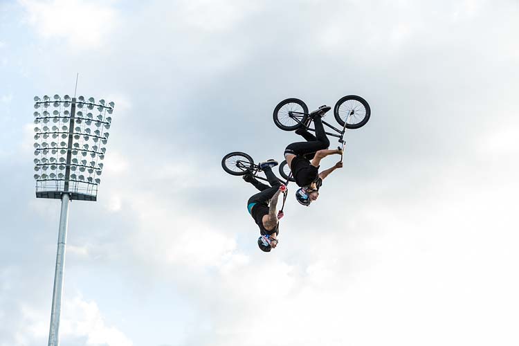 Ryan Williams of Nitro Circus and another bmx rider upside down - doing an aerial trick at a Cairns show