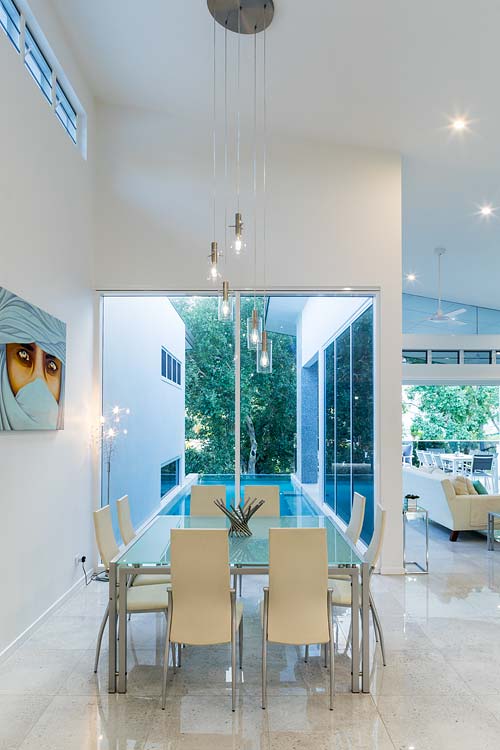 Residential home interior with view of dining area and cantilevered lap pool