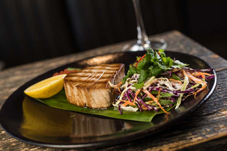A restaurant dish of grilled swordfish and salad