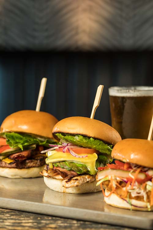 A selection of beef and chicken burgers served with beer