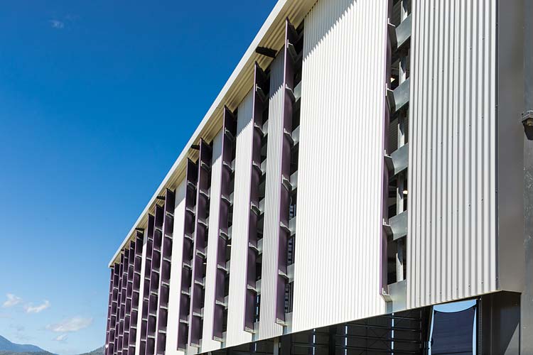 Exterior of covered sports hall showing shade panels on building side