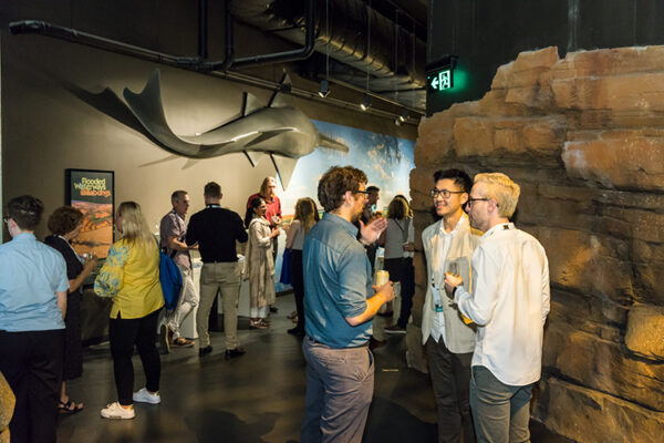 Conference delegates networking at function at an aquarium