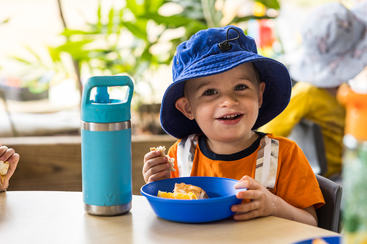 A young boy enjoying a snack at an early education learning centre