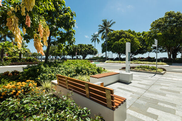 Seating and pedestrian walkway surrounded by tropical gardens