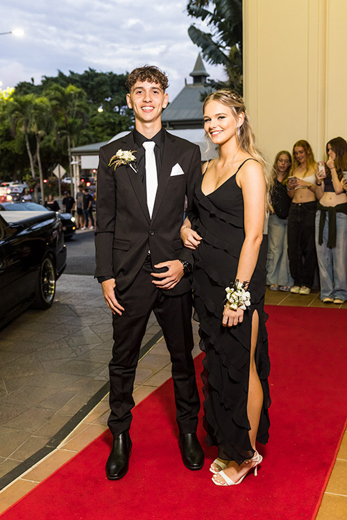 Young couple dressed up on red carpet for school formal arrivals