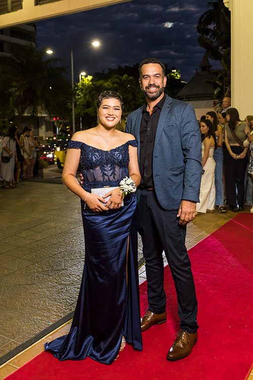 A father and daughter dressed up on red carpet for school formal arrivals