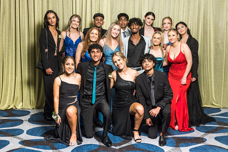 Group photo of male and female students at school formal photographed against a gold backdrop